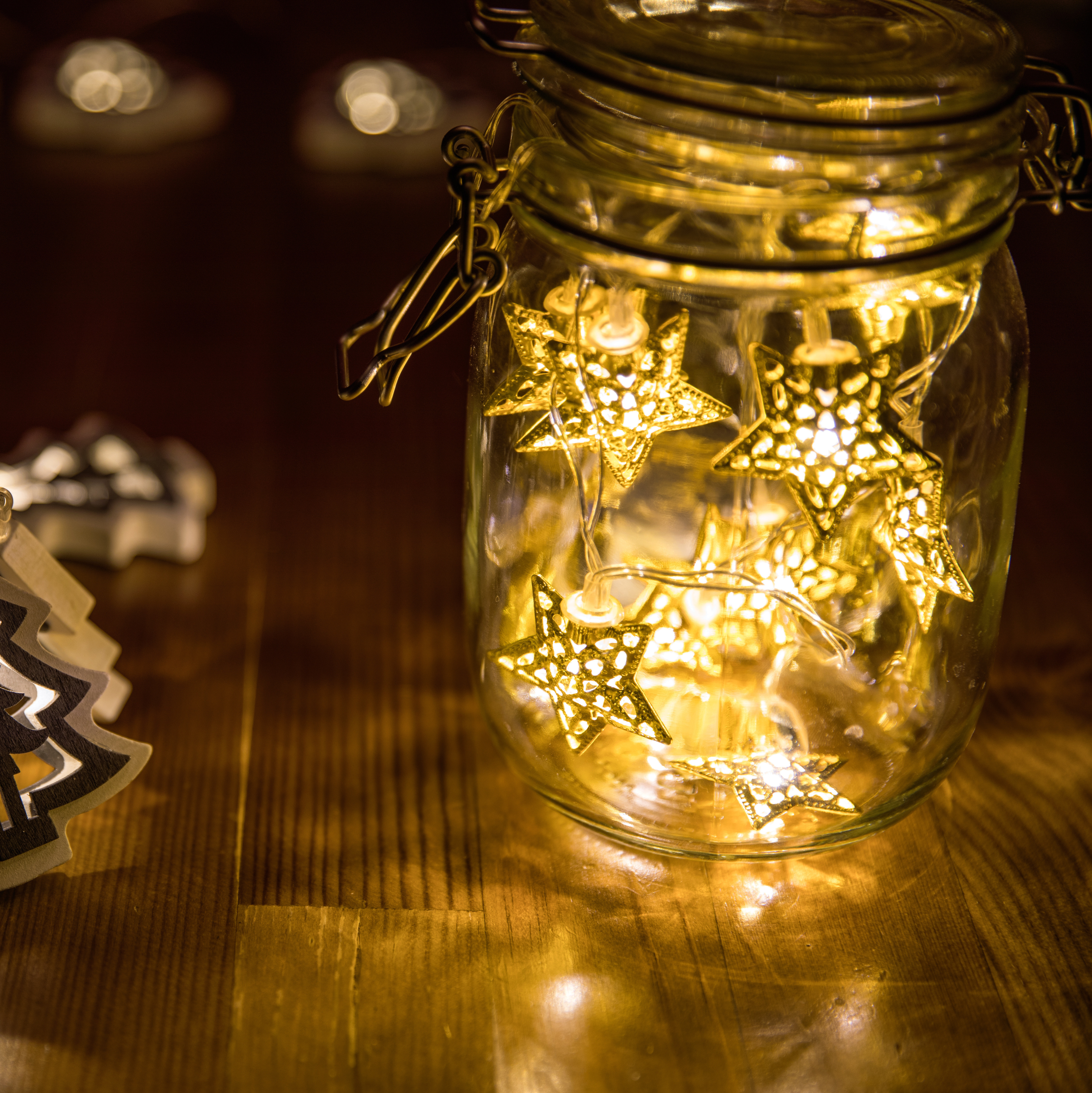 Glass jar lantern illuminated with warm white festive fairy lights creating a simple natural Christmas decoration.