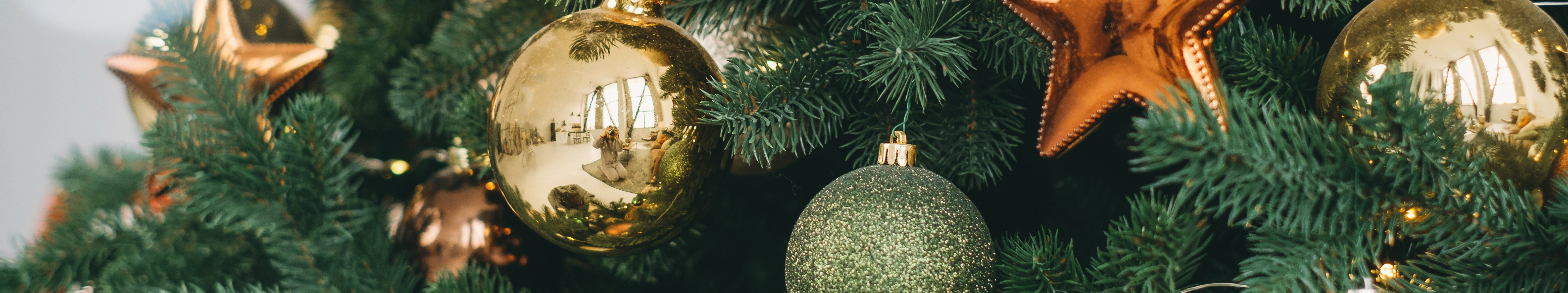 Close up of ornaments on a green Christmas tree