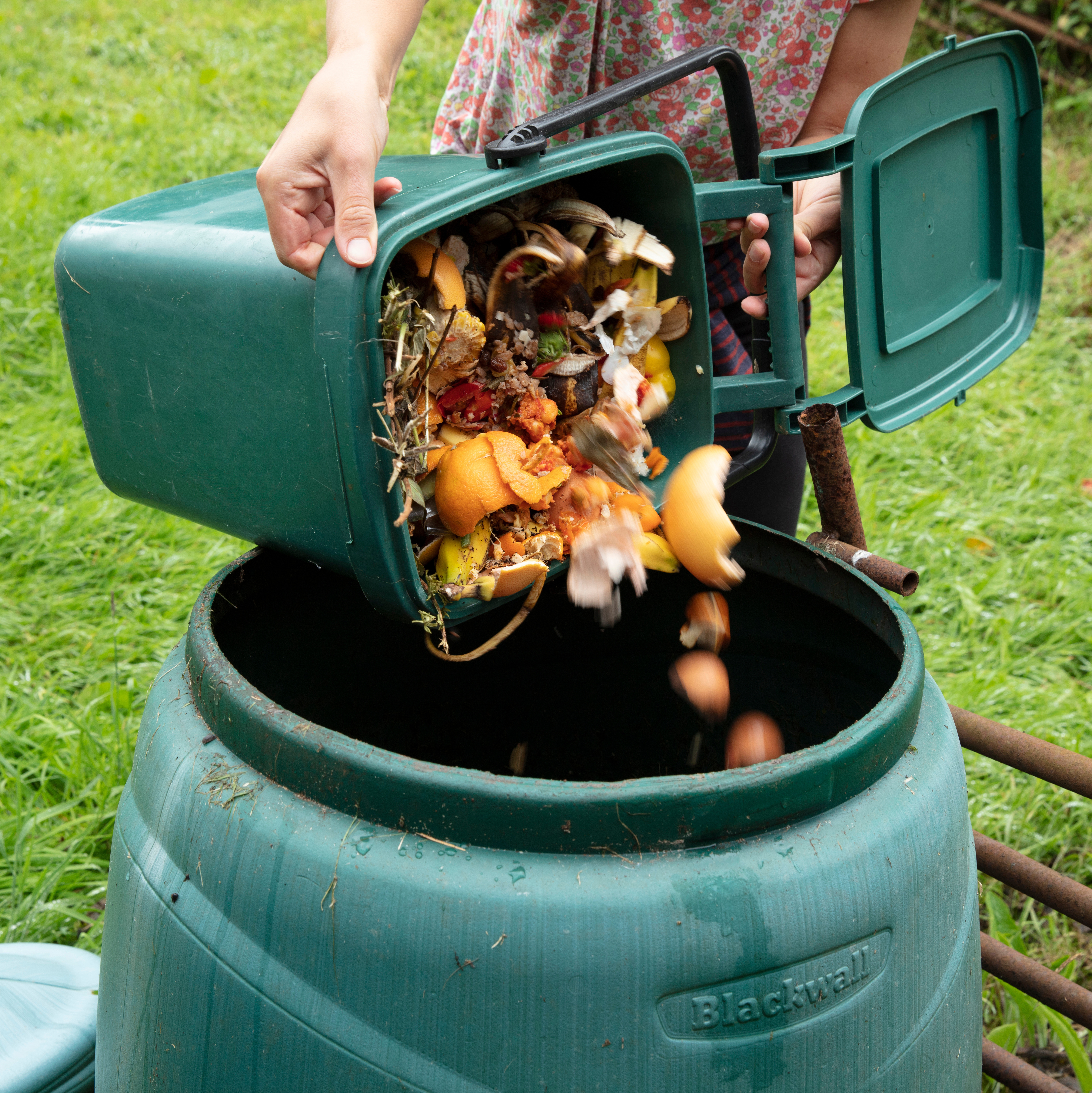 A mix of kitchen green waste being emptied into a compost bin