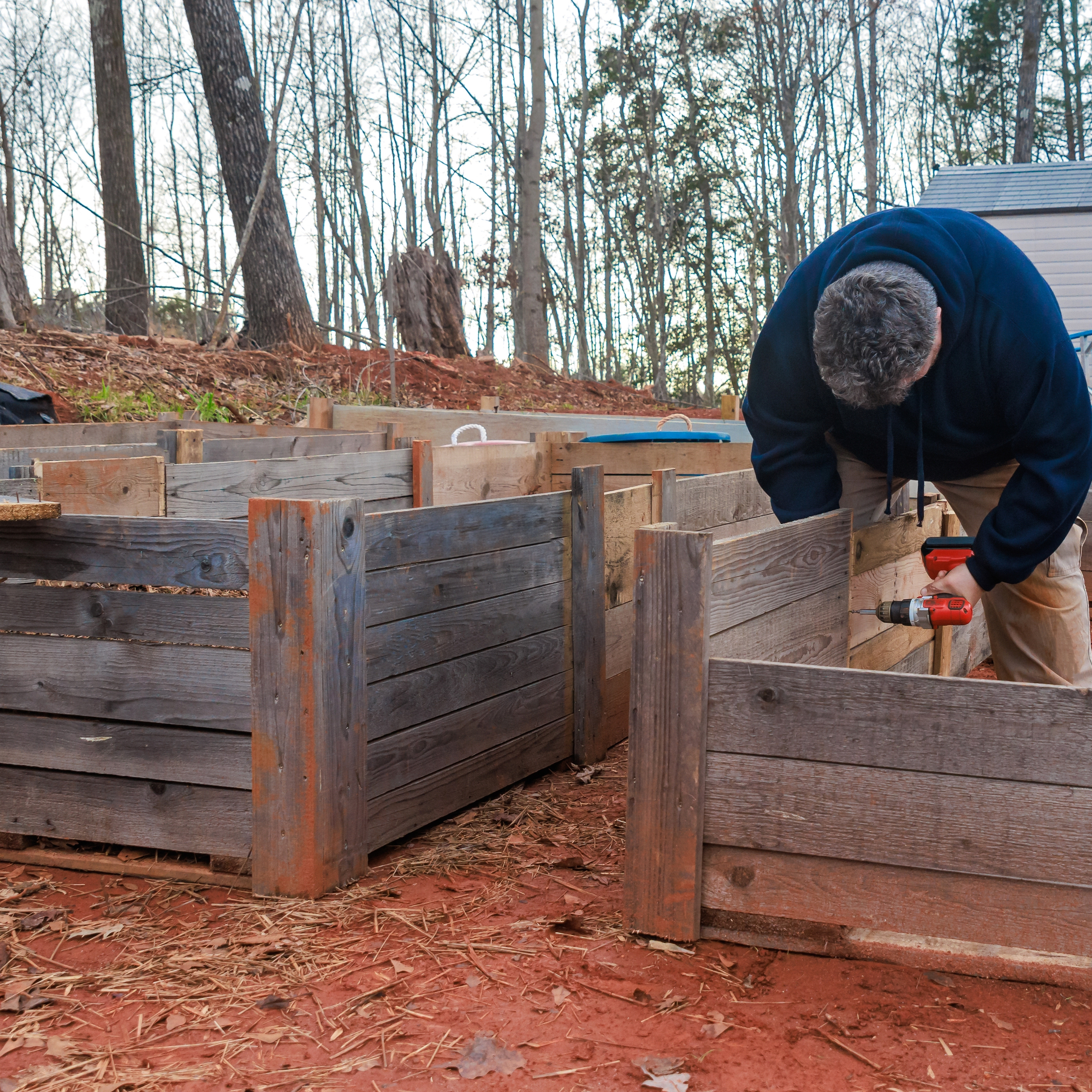 Wooden raised beds under construction and sitting on bare soil