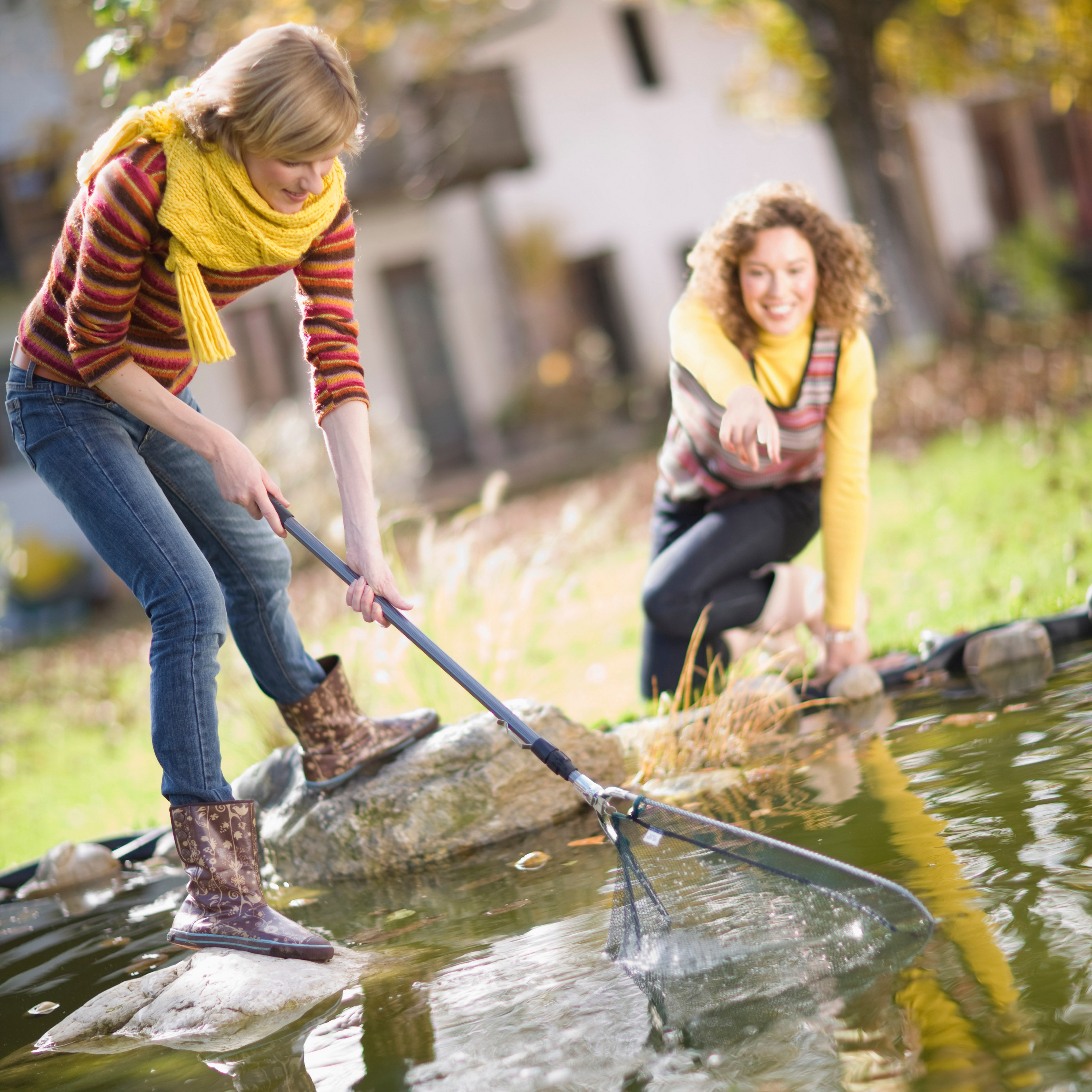 Removing floating debris from a garden pond with a pond net