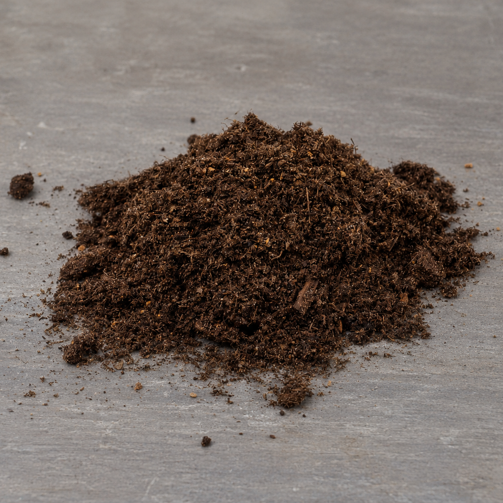 Small pile of fresh houseplant compost on a grey tabletop surface.